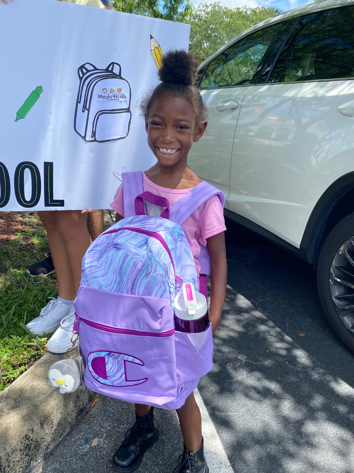 Smiling student with purple Champion backpack