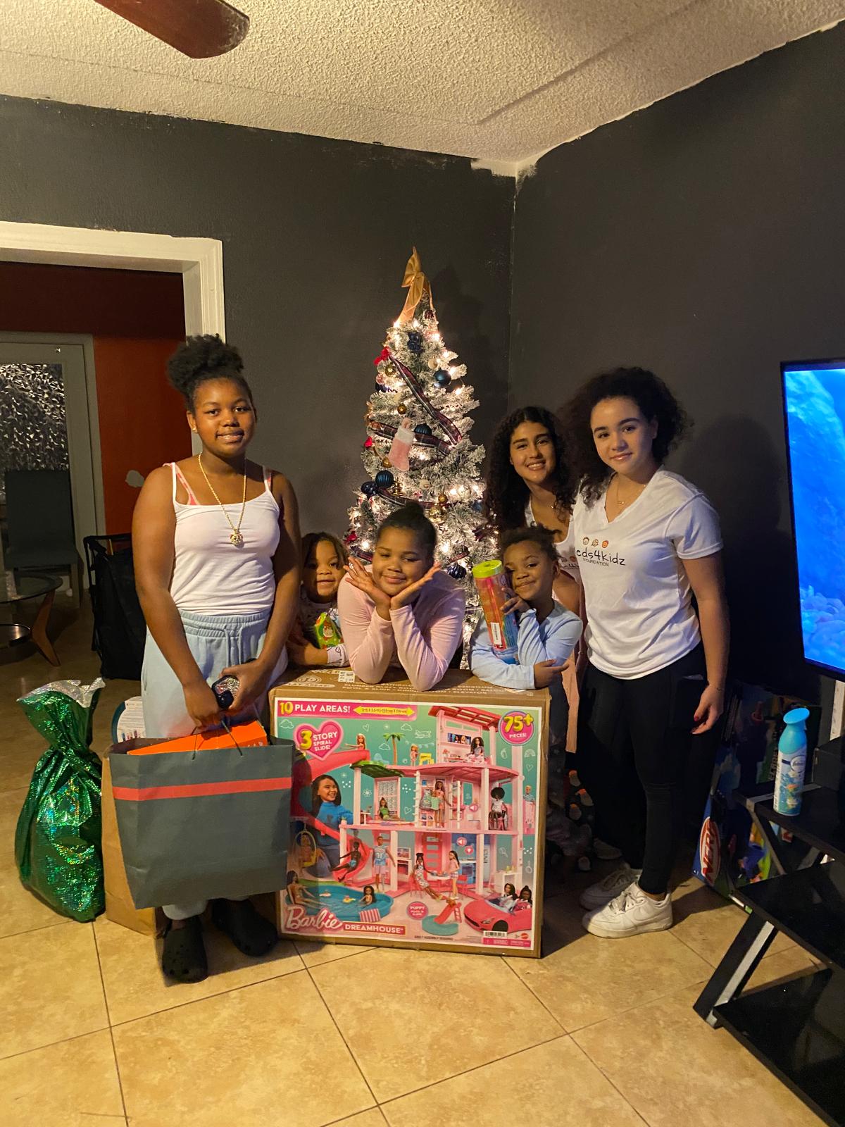Annual Holiday Toy Drive - Daniela and Ariela Delivering Barbie Dreamhouse to Family