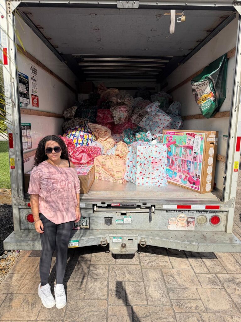 Holiday Toy Drive 2026 - Ariela with Packed Delivery Truck